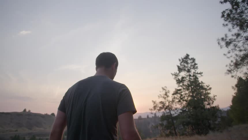 A man walks in the wilderness at sunset