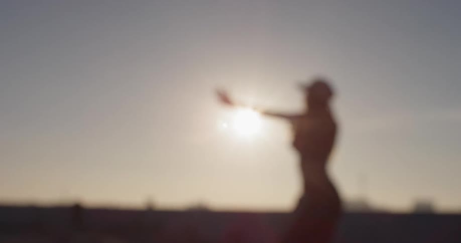 A woman dances on a city building rooftop