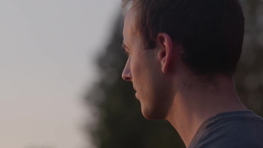 A man in his 20s looks off into the distance