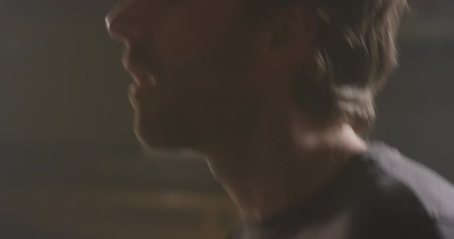 Man moves his head as he moves the drumsticks
