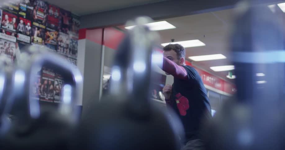 A boxer punches the air in a gym