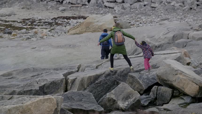 A family walks on rocks