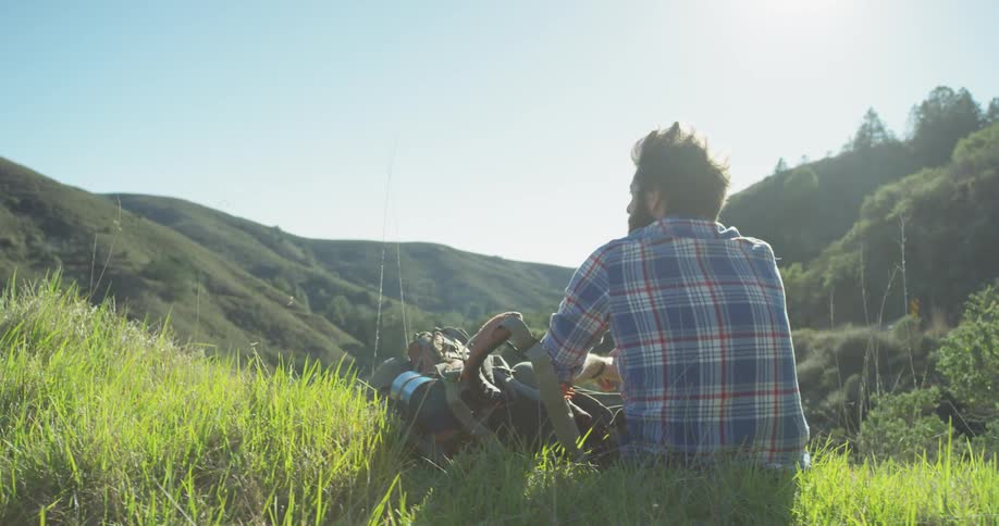 A man sits and rests atop a mountain