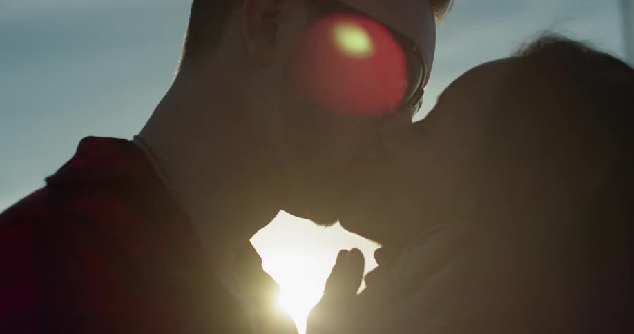 A man and woman kiss outside