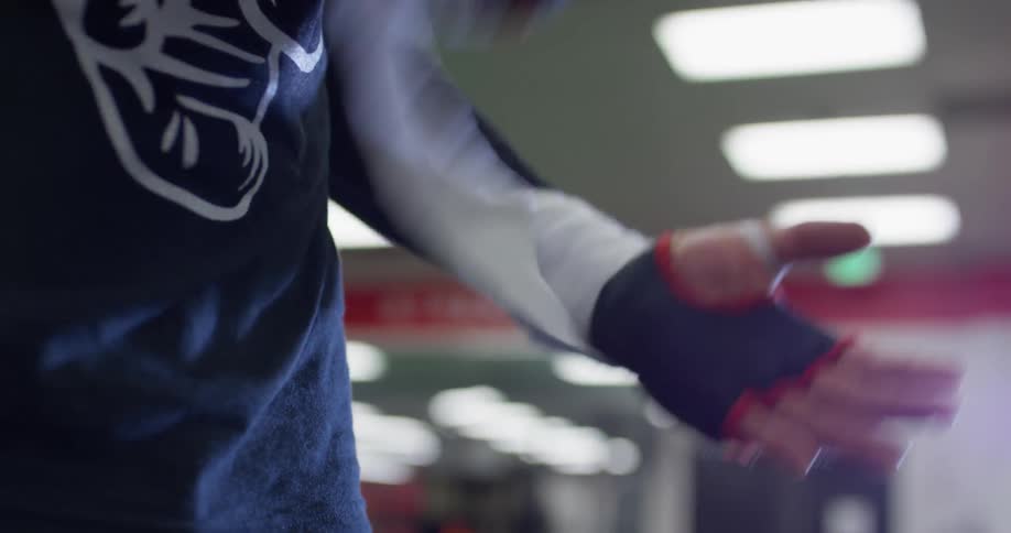 A man unwraps his hands at the gym