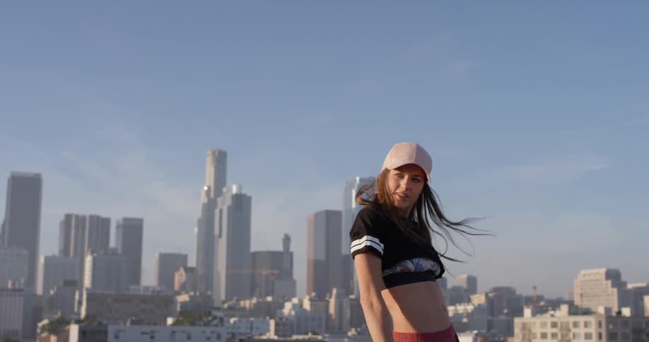 A woman dances on a building rooftop