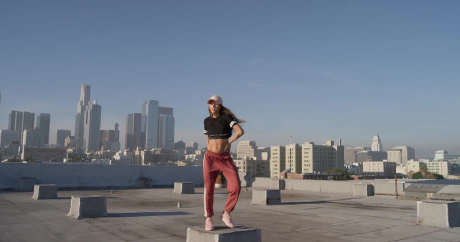 A woman dances on a building rooftop