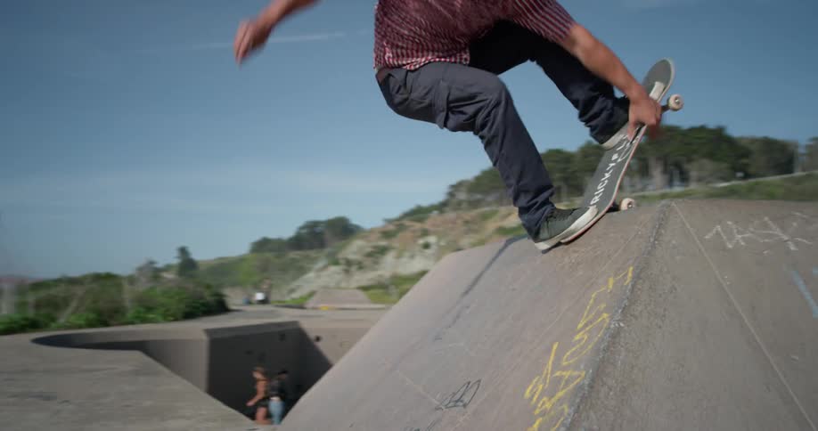 Man skateboards up onto a concrete ledge and back down
