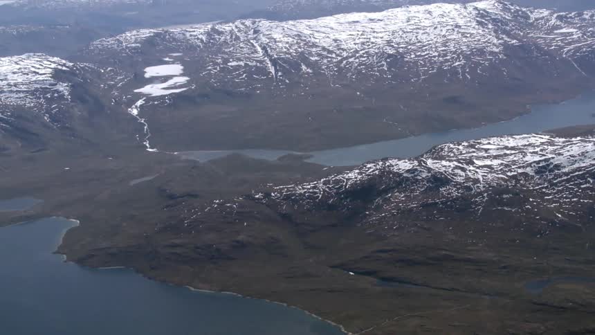A view of snow-capped mountains with a body of water nestled between the peaks