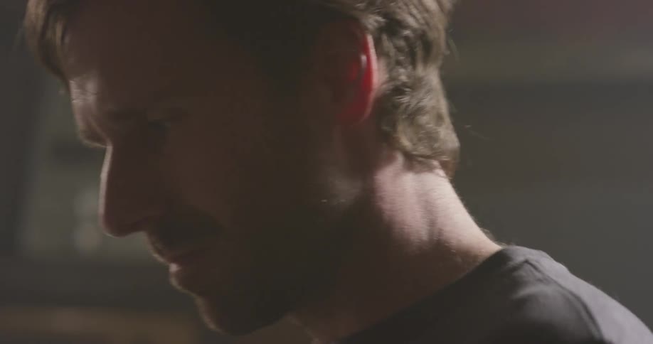 A man nods while playing drums