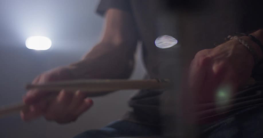A man plays drums with drumsticks