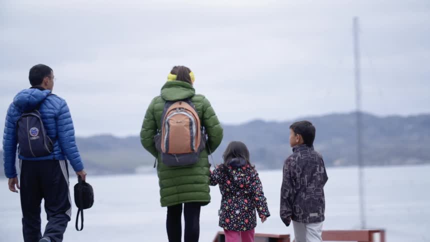 A family walks towards a lake
