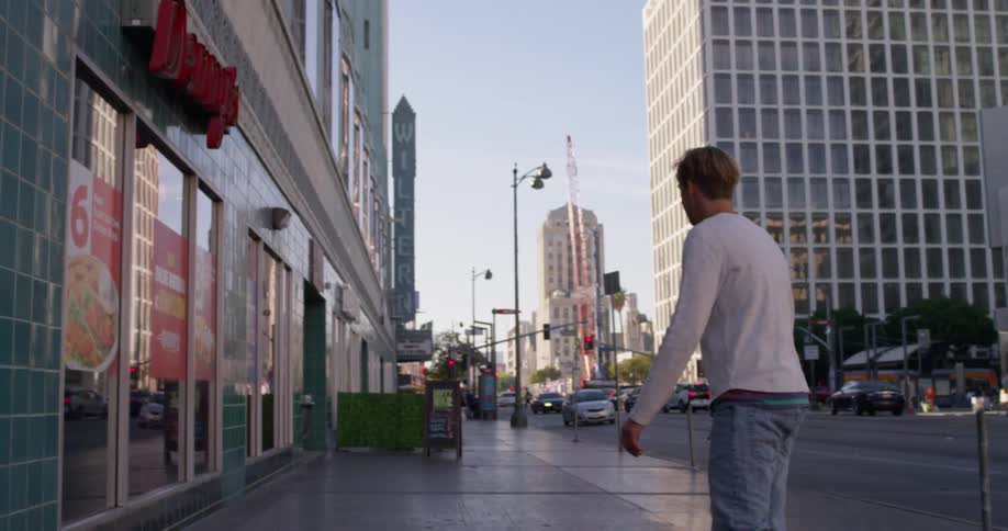Man skateboarding down urban street