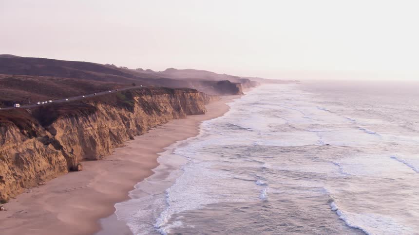 The beach has rough waves hitting the shore