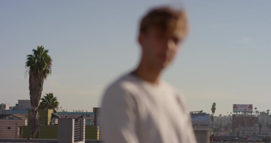 A man stands outside in a city on a sunny day