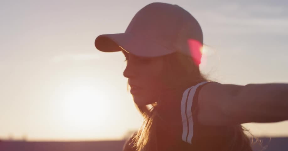 Woman dances on a rooftop in the city at sunset