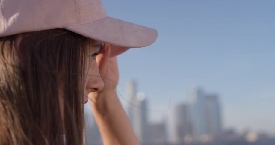 Woman looks around in the city on a windy day