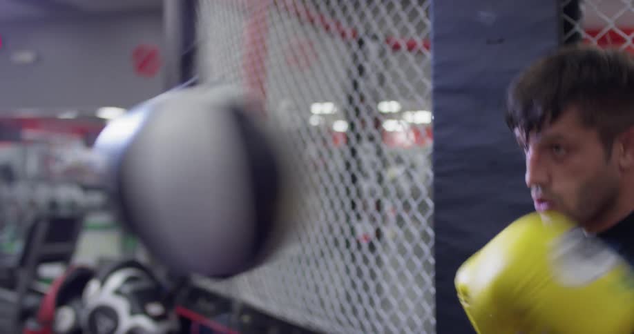 A man trains on a punching bag in a boxing gym