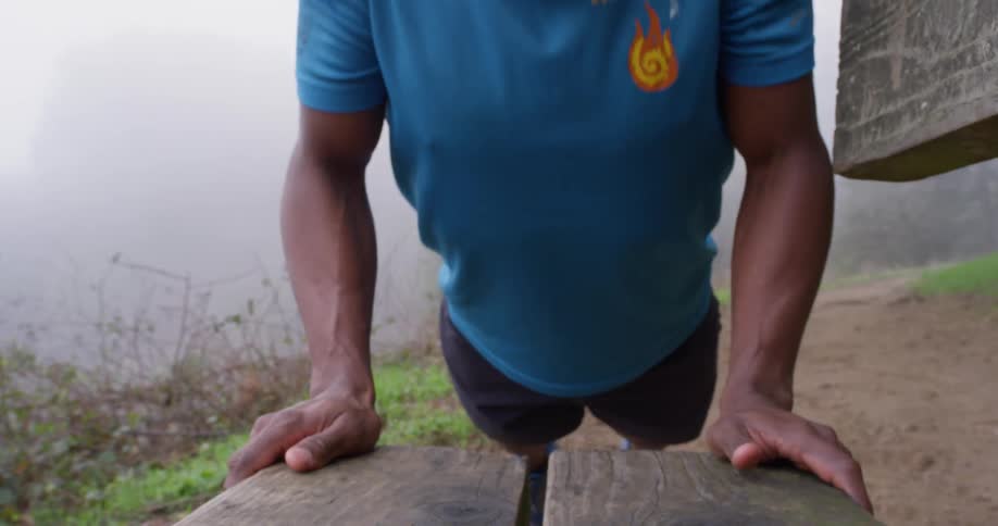 A man is doing push ups on a bench
