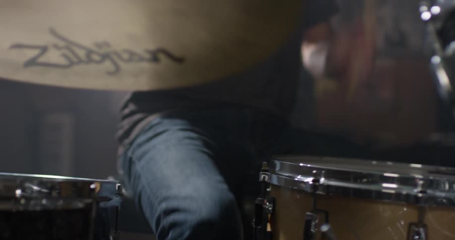 A man plays drums in a garage