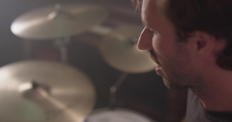A man plays drums in a garage