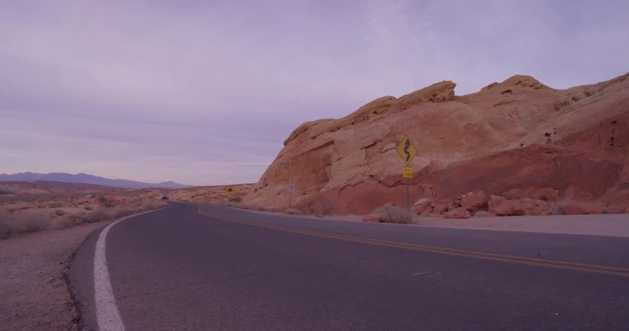 A car travels on an empty desert road