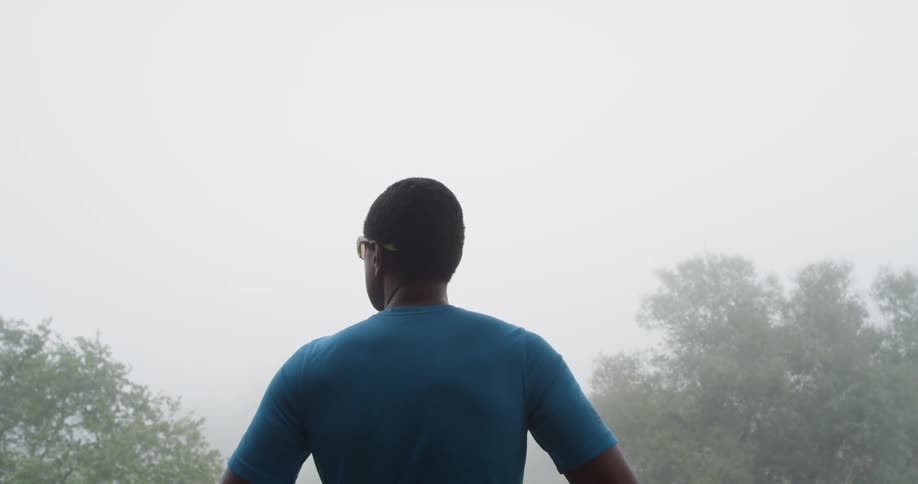 A man stands outside in the fog