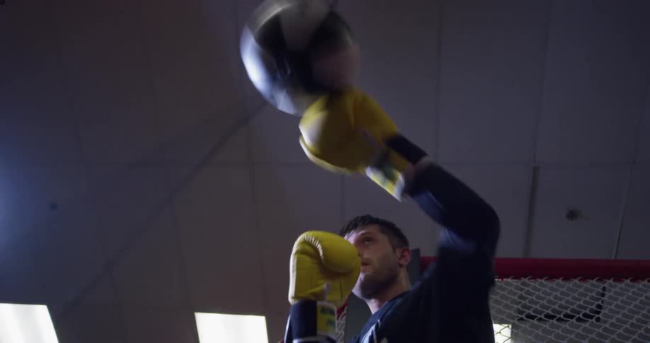 A man is punching a speed bag in the gym