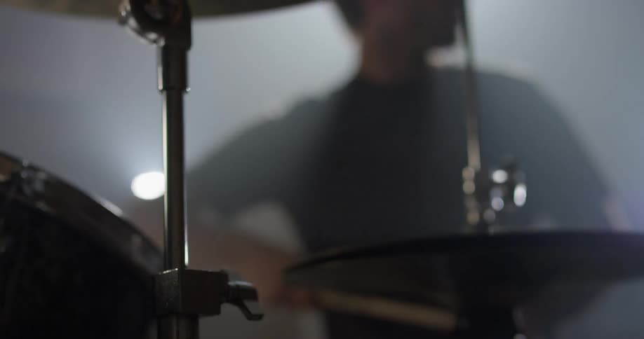 A man plays drums with drumsticks