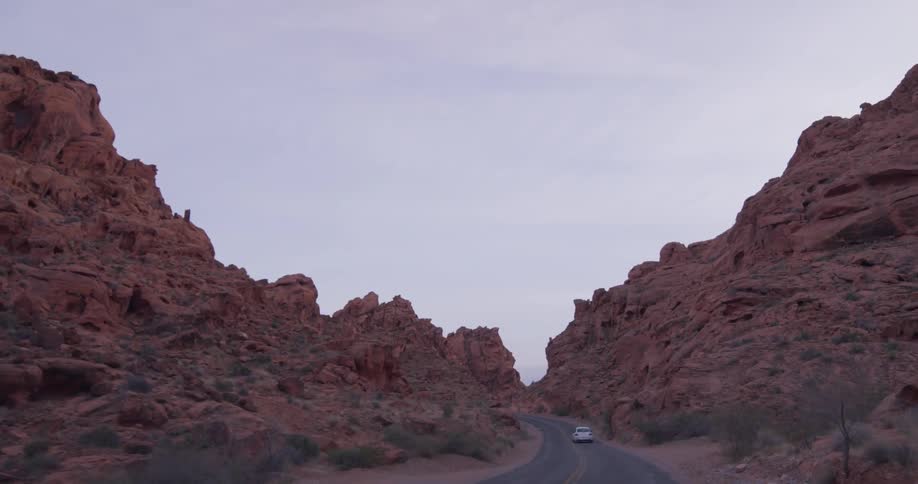 Vehicle travels down the road between the mountains