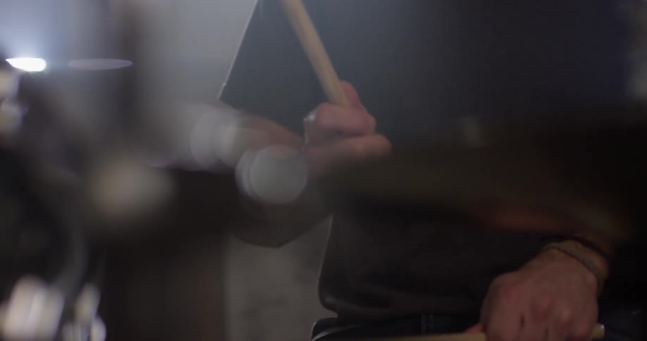 Man drums on a drum set on a sunny day