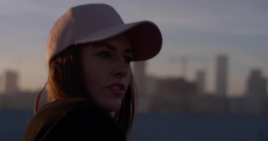 A woman dances happily on a rooftop
