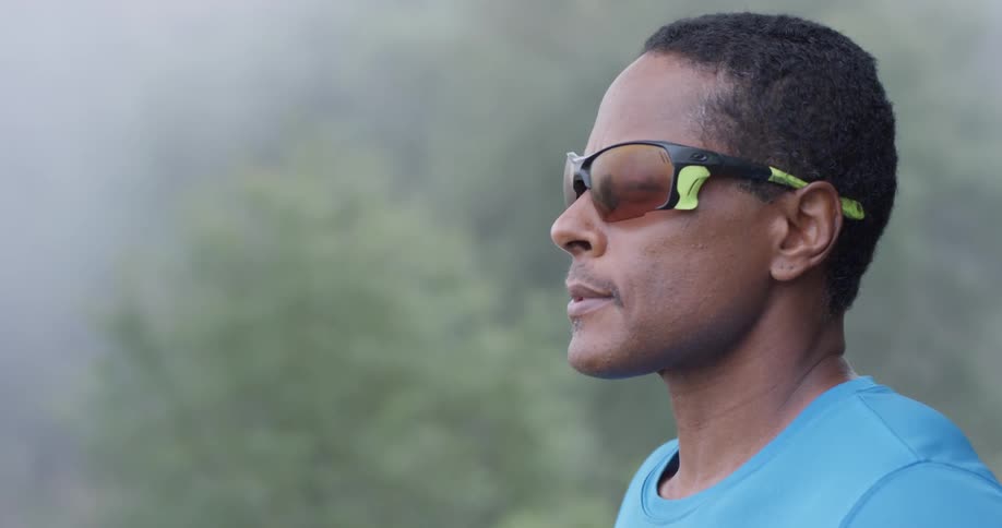 A man wears sunglasses outside on a foggy day