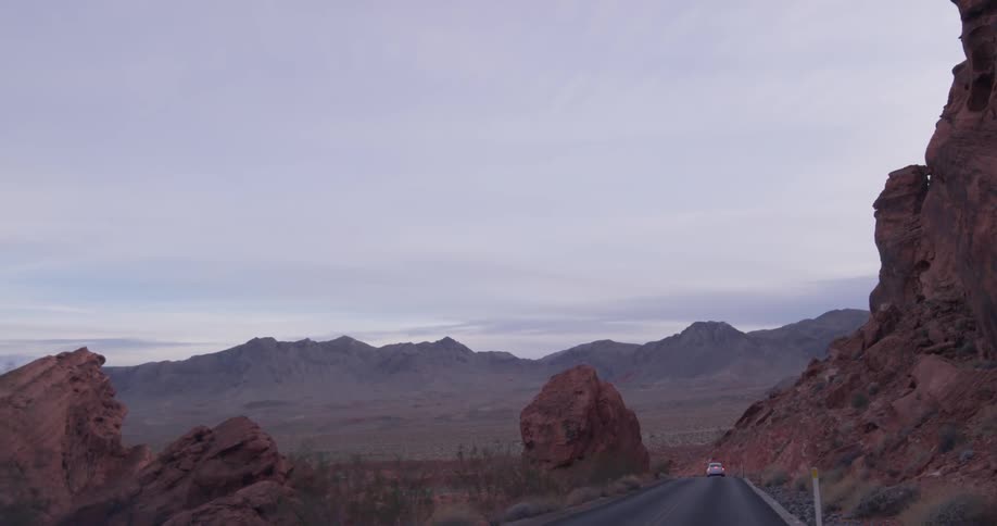 Vehicle drives on a winding road in the mountains and desert