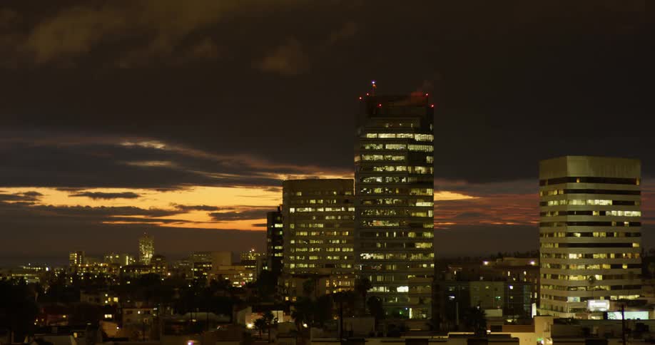 Clouds float over skyscrapers at sunset