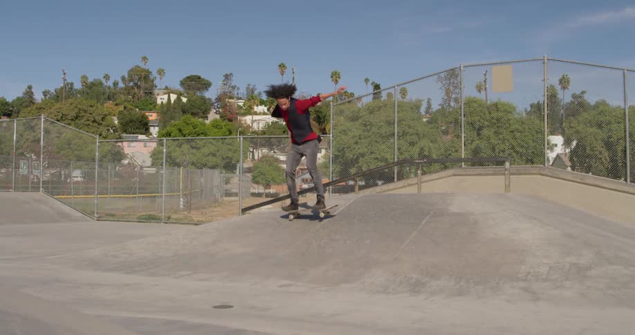 A skateboarder jumps in an outdoor skatepark