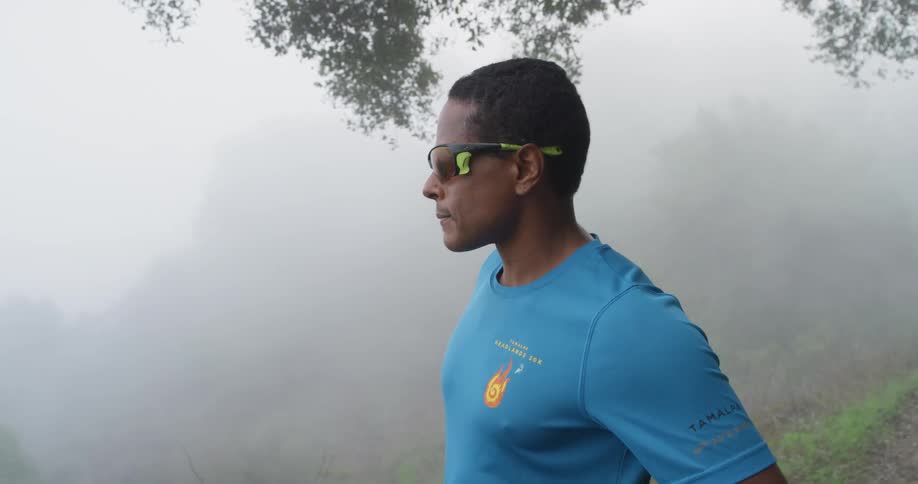A man wears sunglasses in a foggy forest