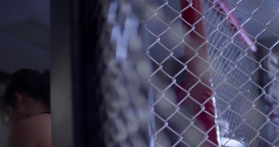 Woman walks out of a fenced in area of a gym
