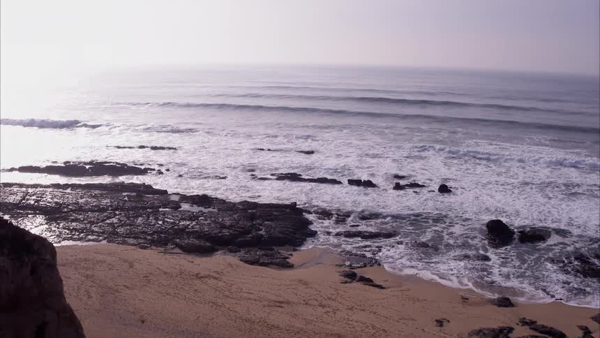 The ocean tide rolls in onto the beach
