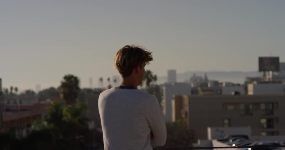 Man on roof looking at city