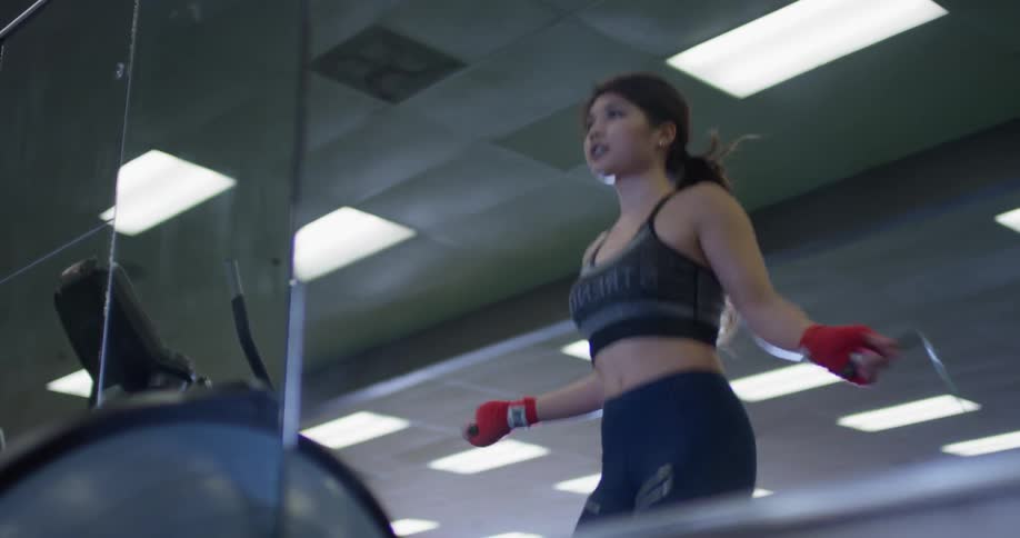 A woman jumps rope in a gym