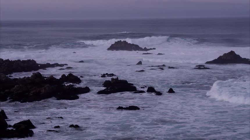 The waves crash as they reach the rocky shore