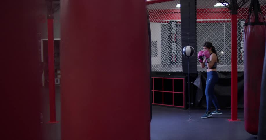 Woman hits a punching bag in a gym