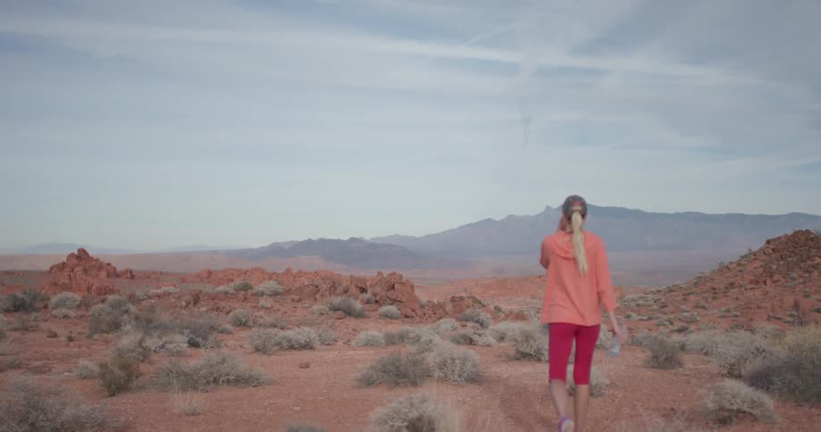 A woman hikes outside carrying a water bottle
