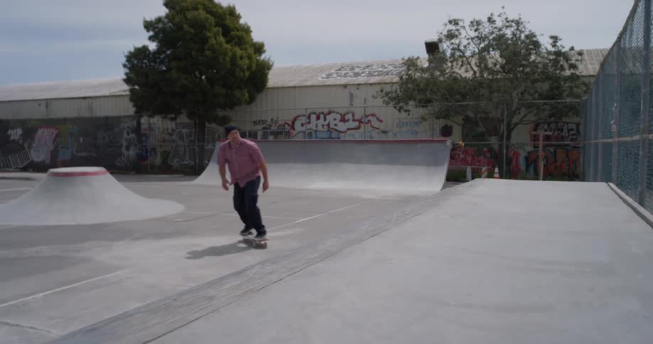 A man skateboards at an outdoor skatepark