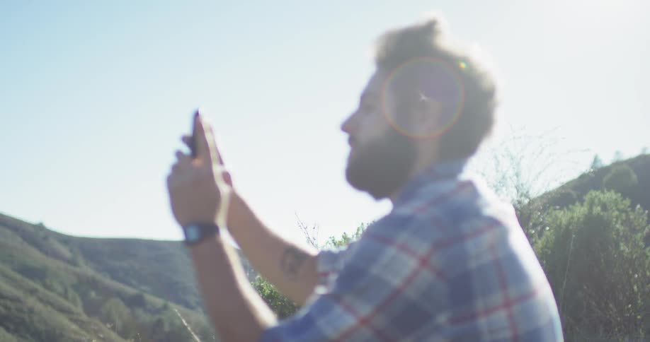 A hiker takes pictures from atop the mountain