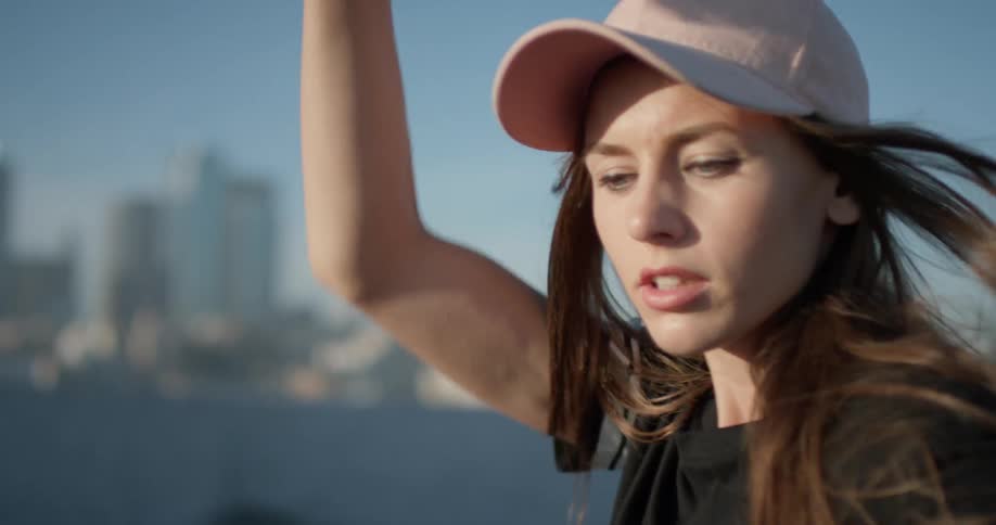 Woman stands outside stretching and moving her arms