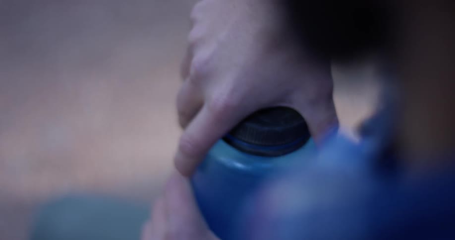 A man opens up his water bottle