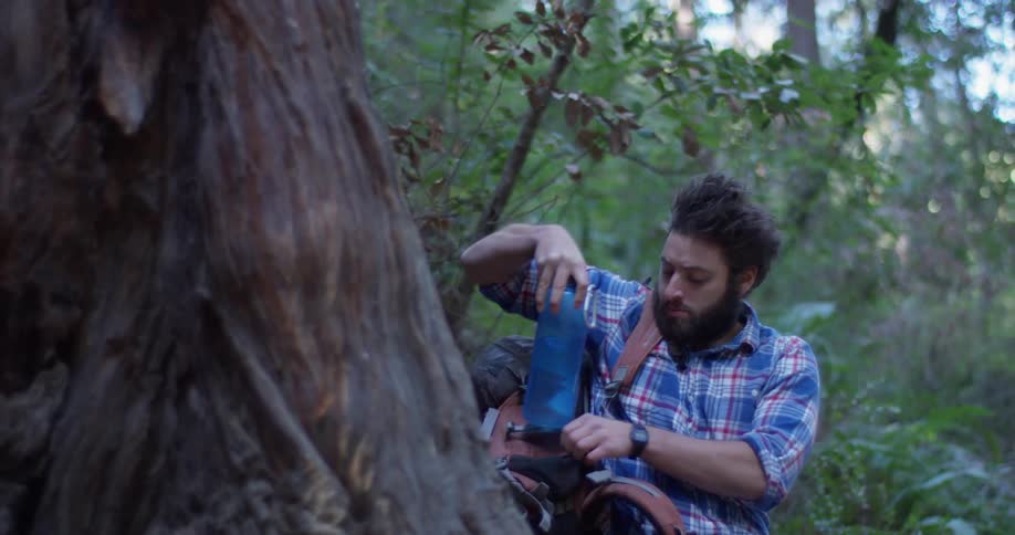 A hiker puts a water bottle back into his bag