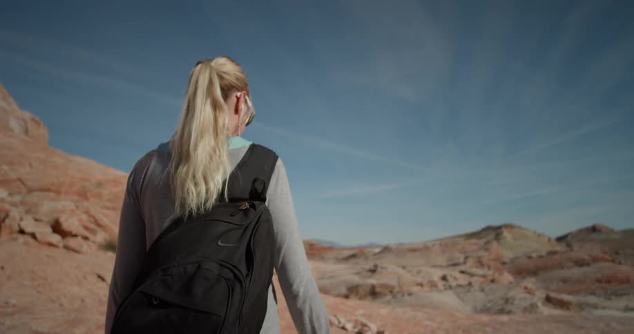 A woman hikes alone in a desert